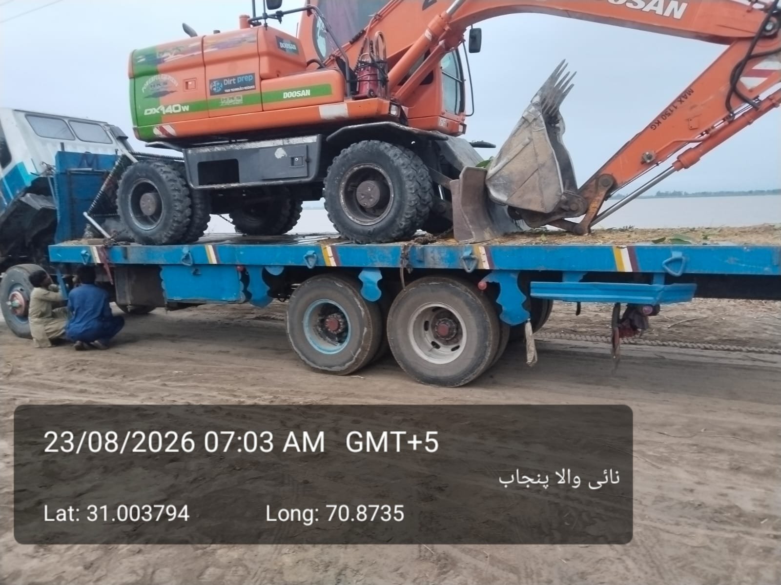 Heavy machinery and excavators being transported on a truck to reinforcement sites during Indus River flood relief efforts in Layyah.