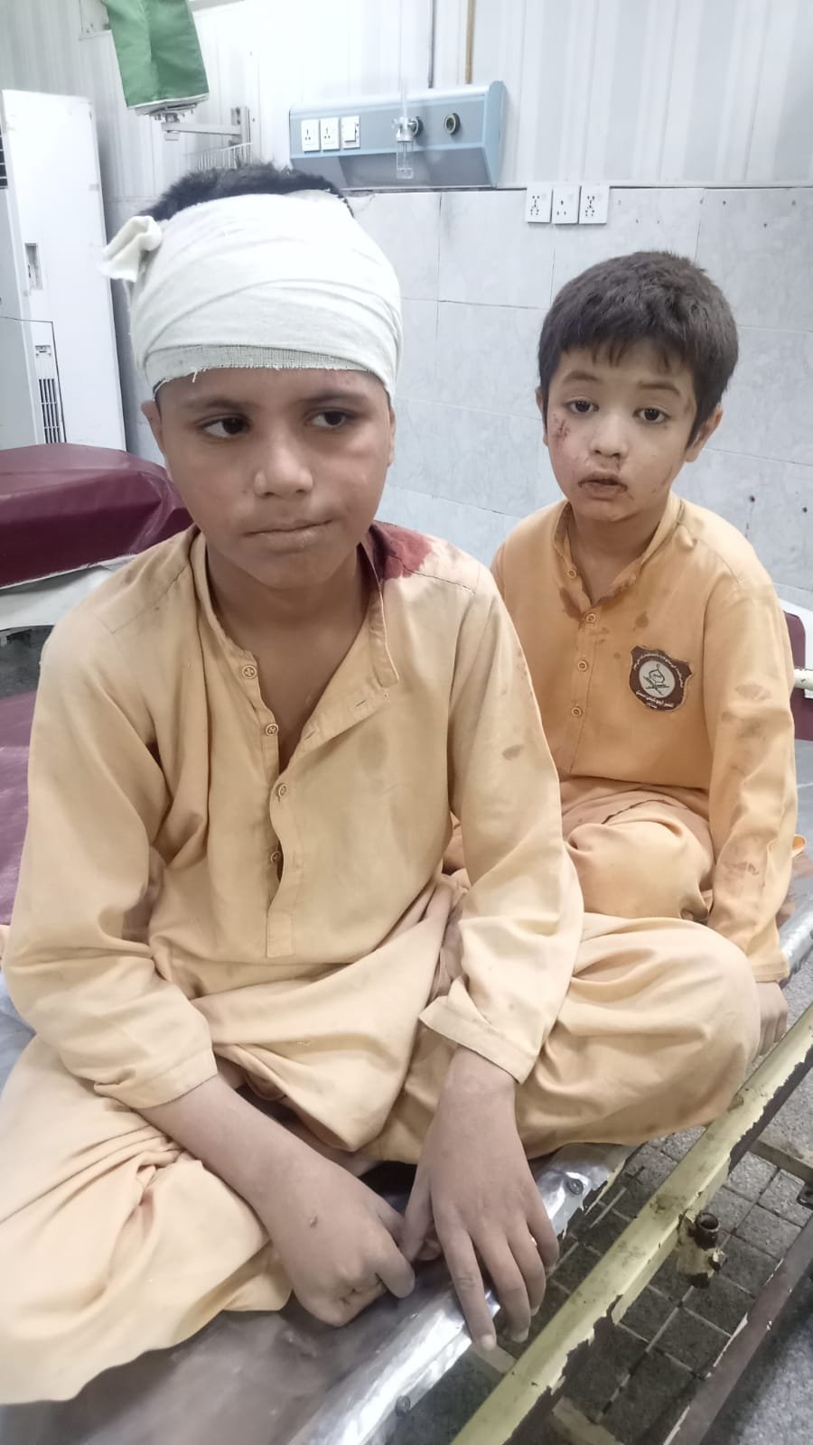 Young student in uniform looking forward following the tragic school roof collapse in Peshawar.